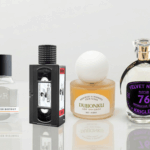 A banner-style photograph featuring four unique perfume bottles arranged on a glossy white reflective table. From left to right: Fulton & Roark, Xyrena, KST Scent, and Krigler.