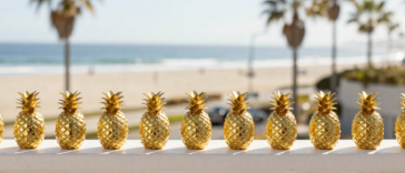Golden Pineapple trinkets lined up on balcony rail.