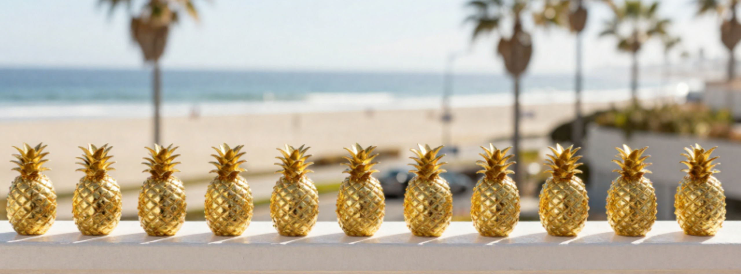 Golden Pineapple trinkets lined up on balcony rail.